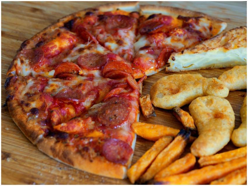 Close-up of pepperoni pizza, battered chicken, and
