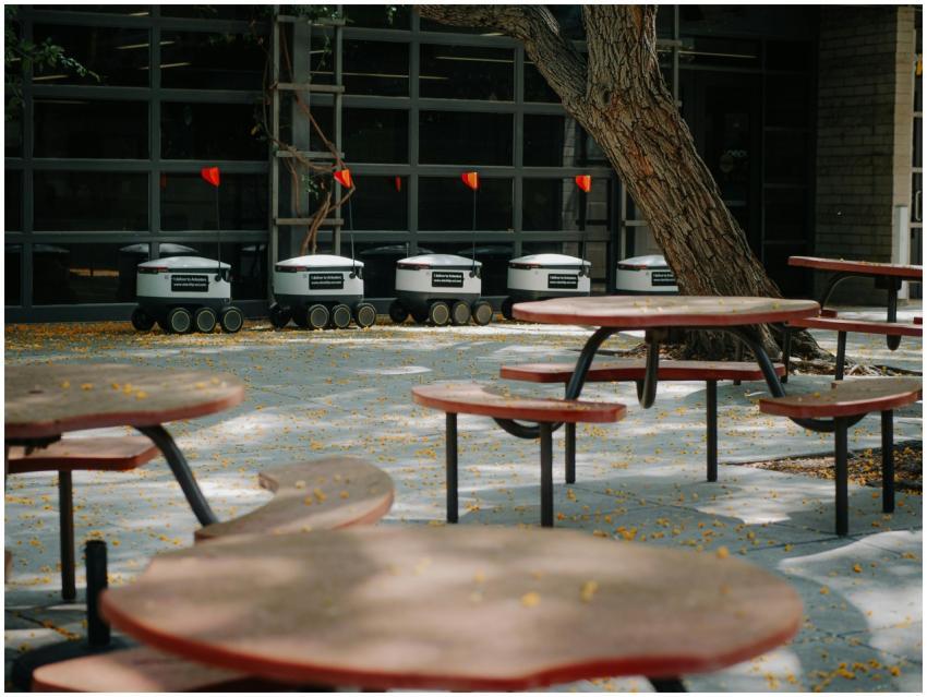 Futuristic delivery robots lined up near outdoor c