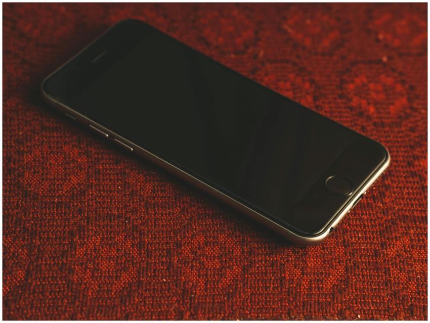 A smartphone resting on a textured red fabric surf