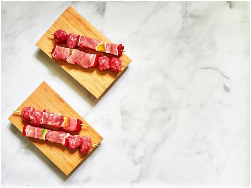 Top view of raw meat skewers on wooden boards read