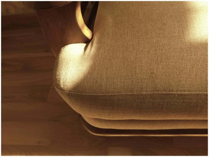 Brown fabric sofa catching warm sunlight, casting