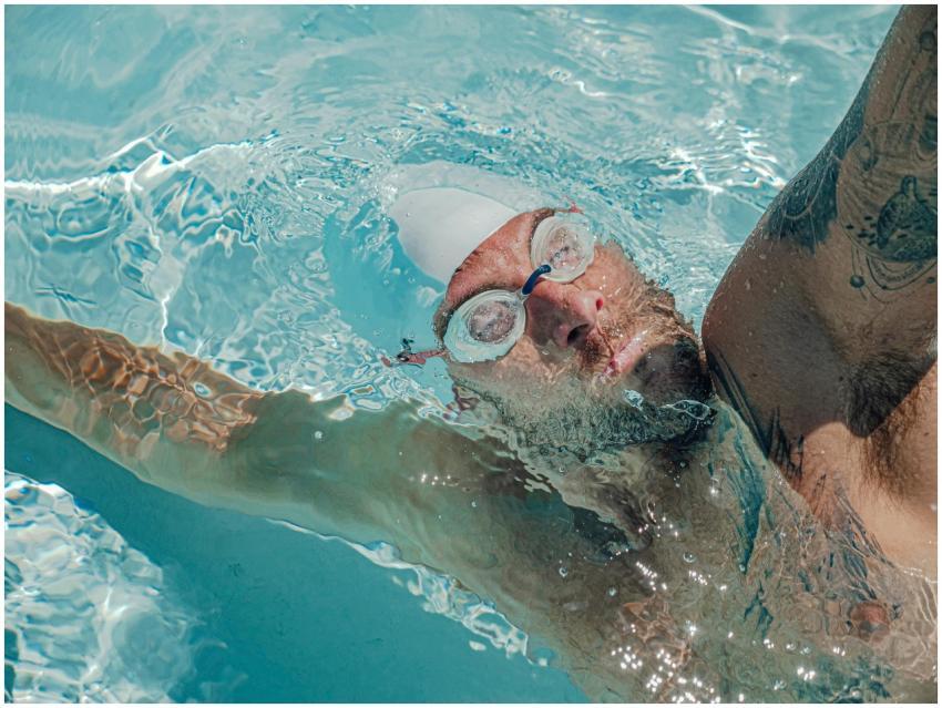 An adult male swimmer training in a pool, wearing