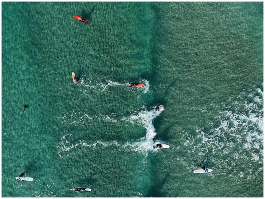 High-angle shot capturing surfers on vibrant ocean