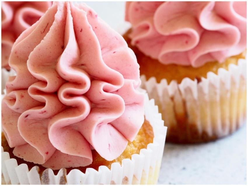 Delicious close-up image of pink-frosted cupcakes,
