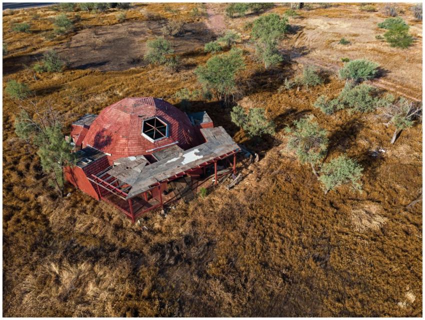 Drone shot of a decaying dome-shaped house surroun