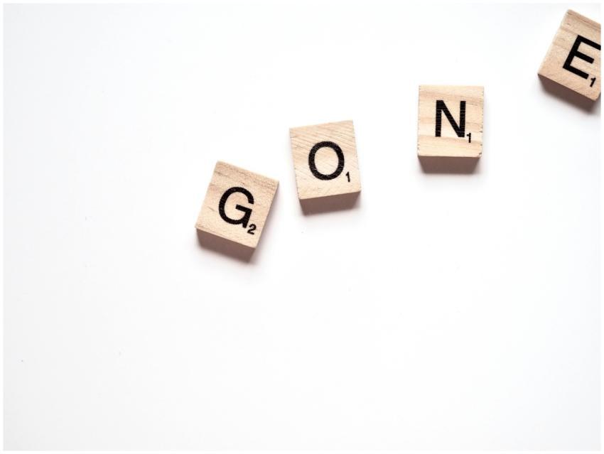Wooden tiles on white surface spell the word 'Gone