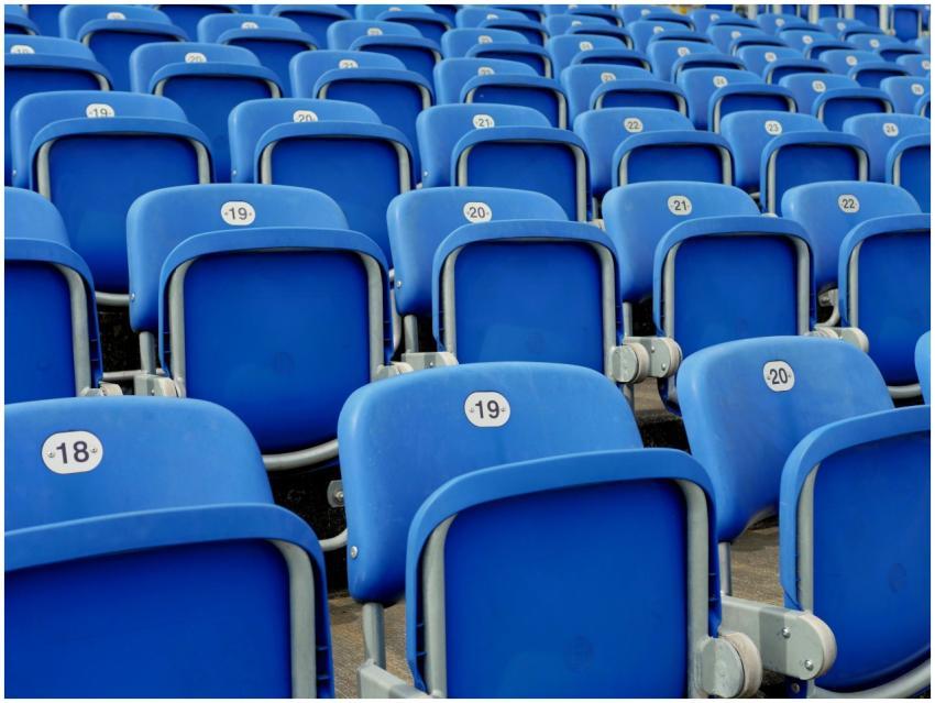 Rows of blue plastic stadium seats numbered and al