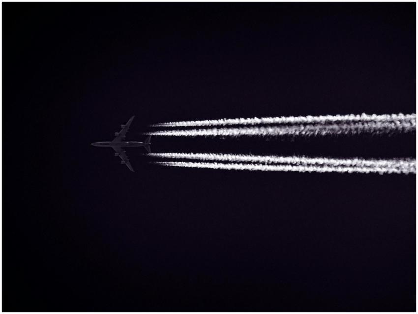 A jet airplane leaves contrails as it flies throug