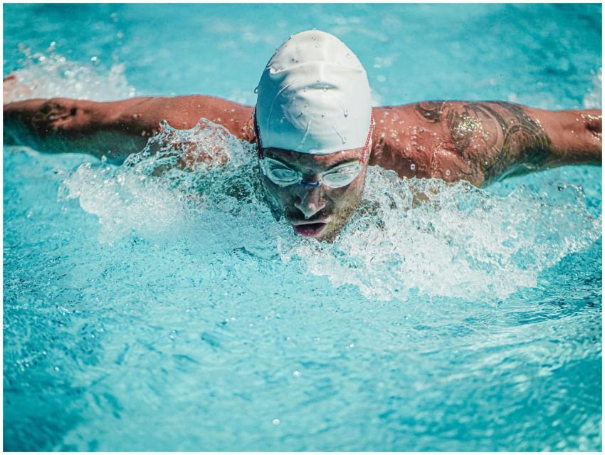 Male athlete executing butterfly stroke in a swimm