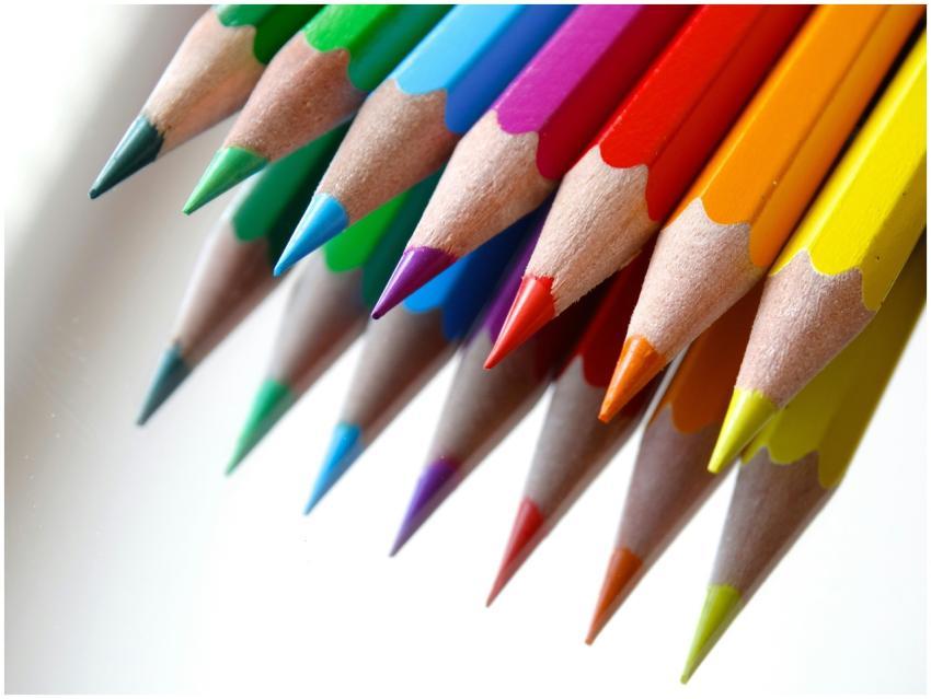 Vibrant colored pencils arranged on a white backgr