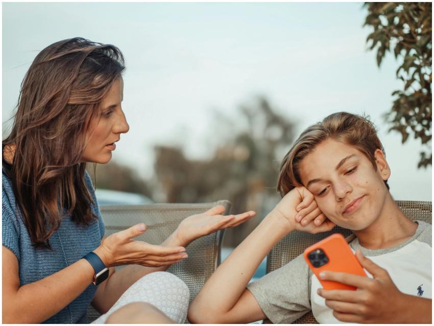 A mother engaging with her teenage son holding a s