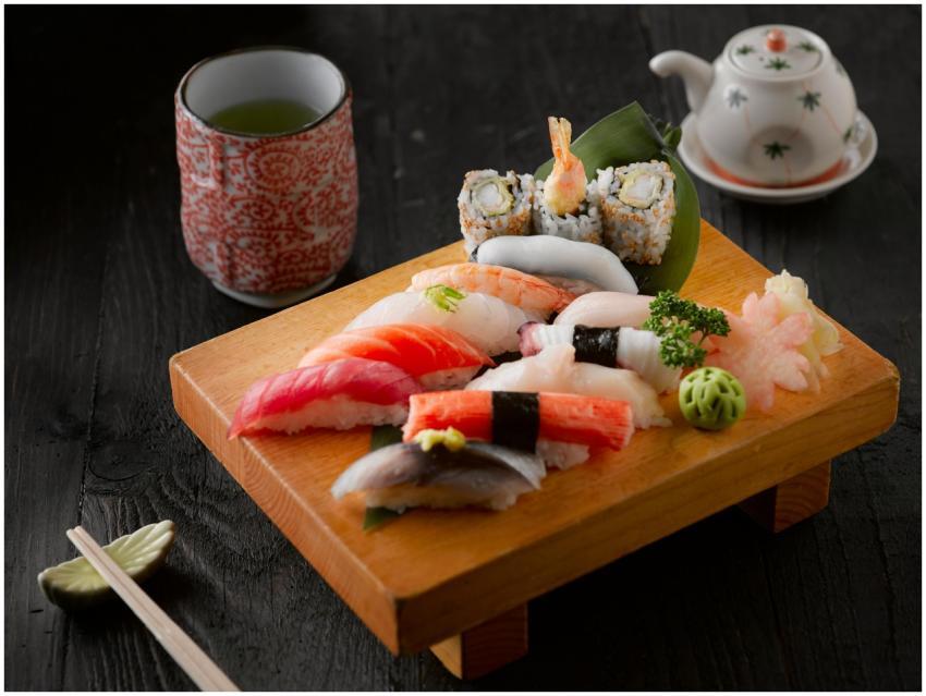 Elegant display of sushi with green tea on a woode