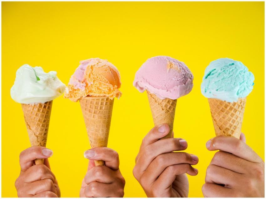 Four colorful ice cream cones held up against a br