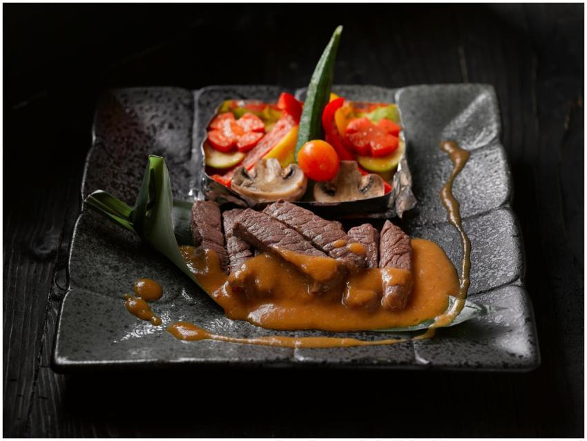 Elegant beef dish with vegetables and sauce on a d