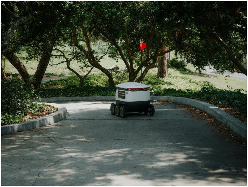 An autonomous delivery robot moves through a shade