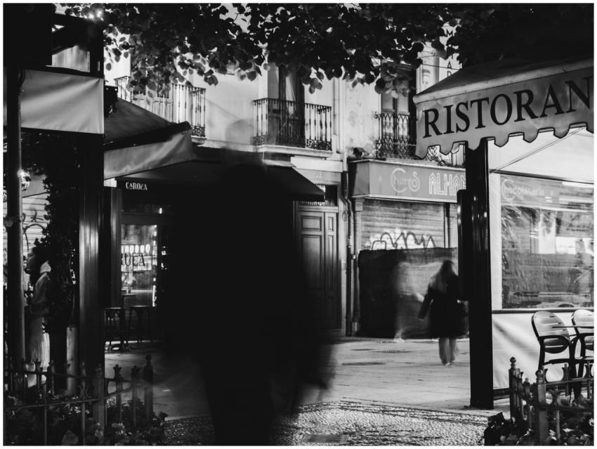 Black and white photo capturing blurred pedestrian