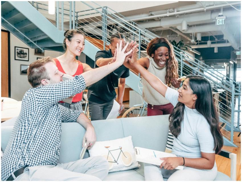 A diverse team celebrates success with a high-five