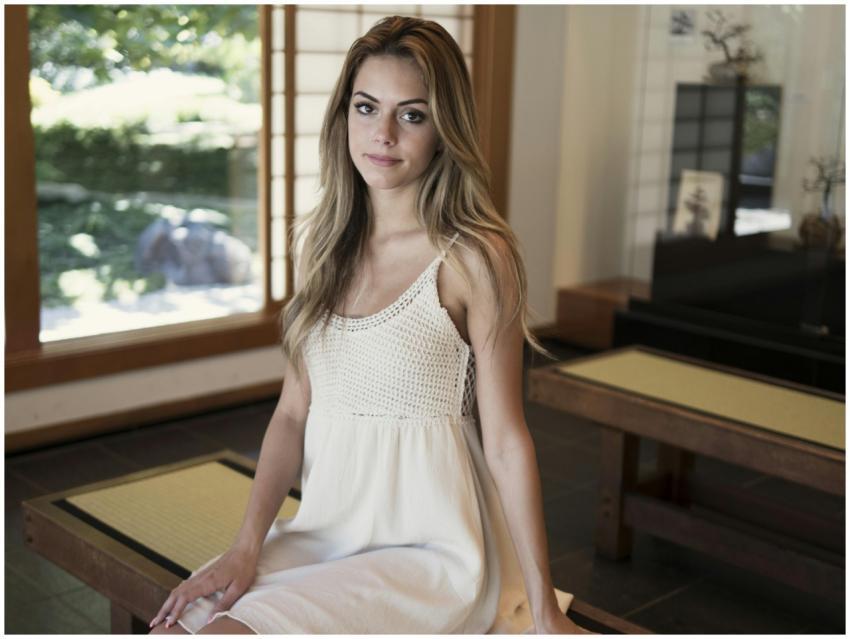 A serene portrait of a woman sitting indoors in na