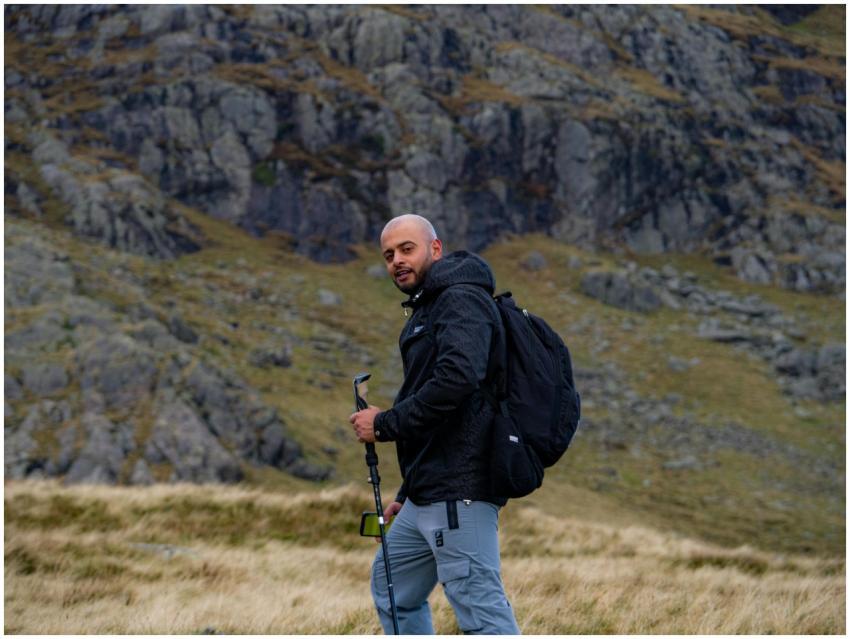 Man hiking with a backpack and trekking pole in ru