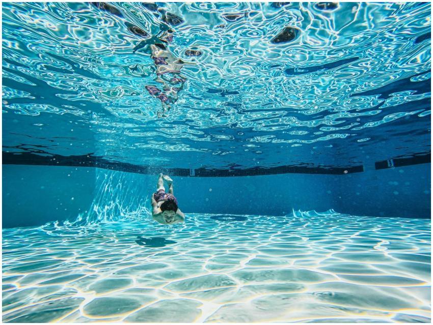 Underwater photo capturing a boy swimming in a cle