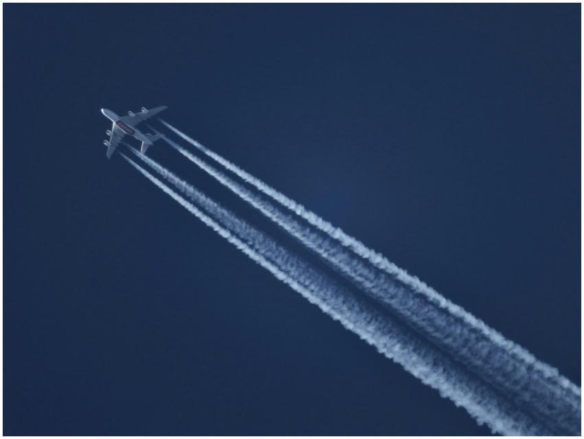 High-altitude airplane leaving contrails in a clea
