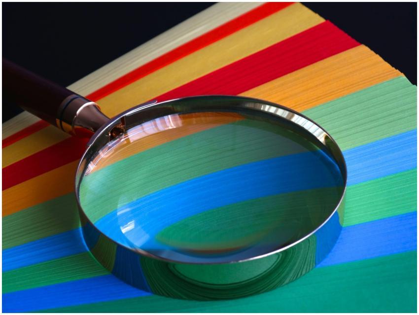 Magnifying glass resting on vibrant rainbow-colore