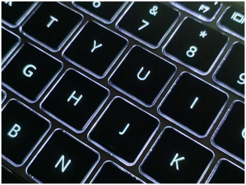 A detailed close-up photo of a backlit laptop keyb