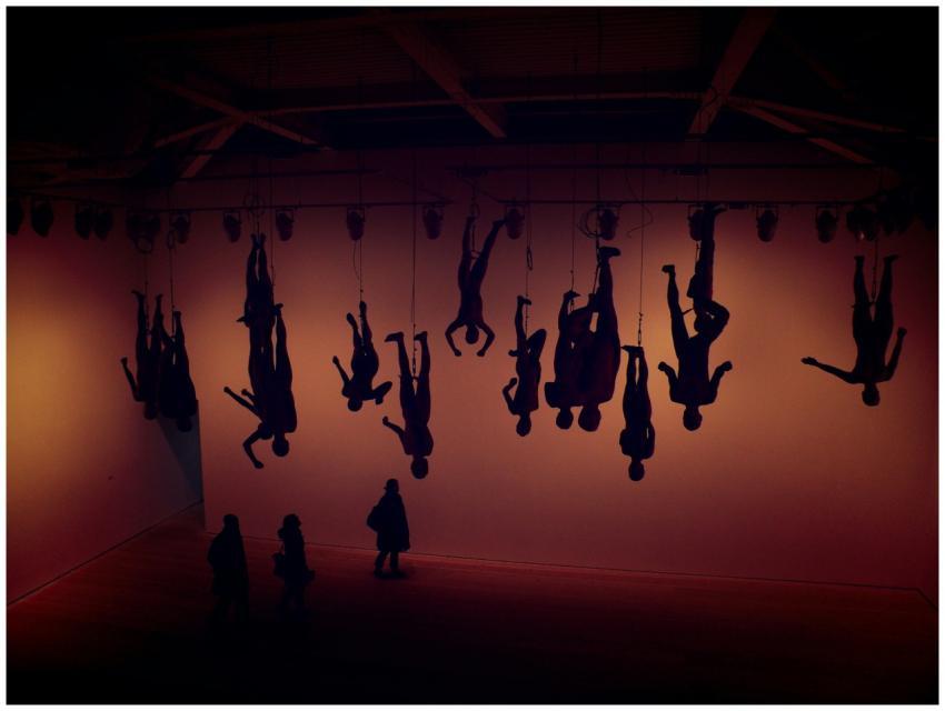 Silhouette of hanging figures in a London gallery