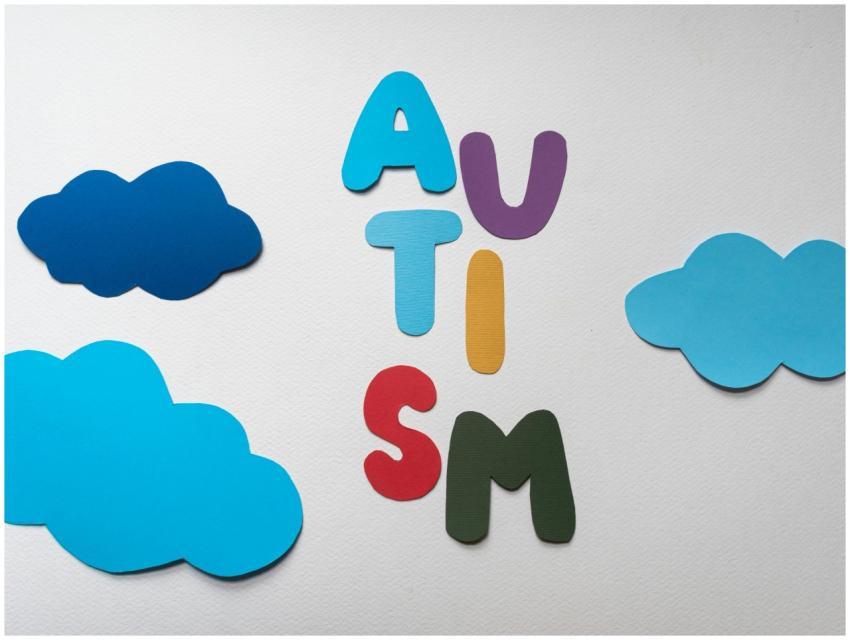 Vibrant letters spelling 'AUTISM' surrounded by bl