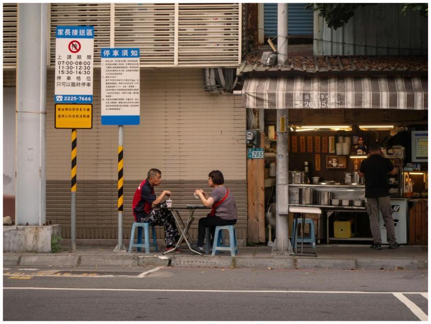 Two adults enjoying a meal at a street-side table
