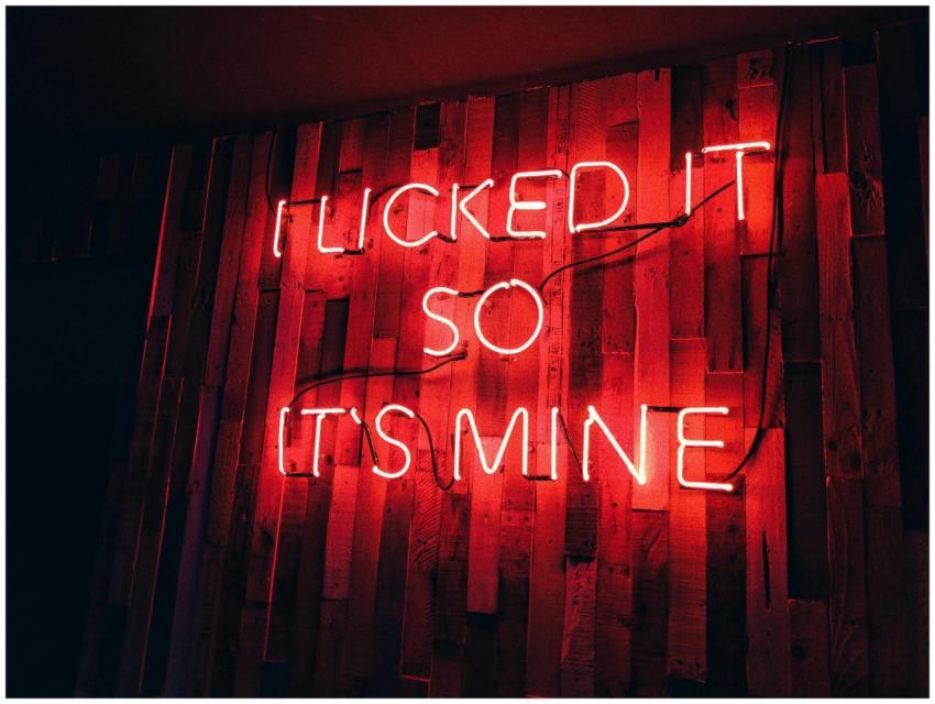 Vibrant red neon sign displays playful text on a r