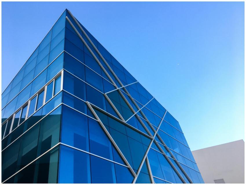Striking blue glass building against a clear sky i