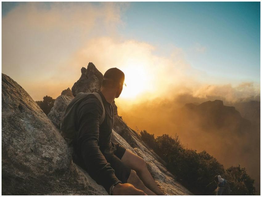 Man enjoying a breathtaking mountain sunset in Wai