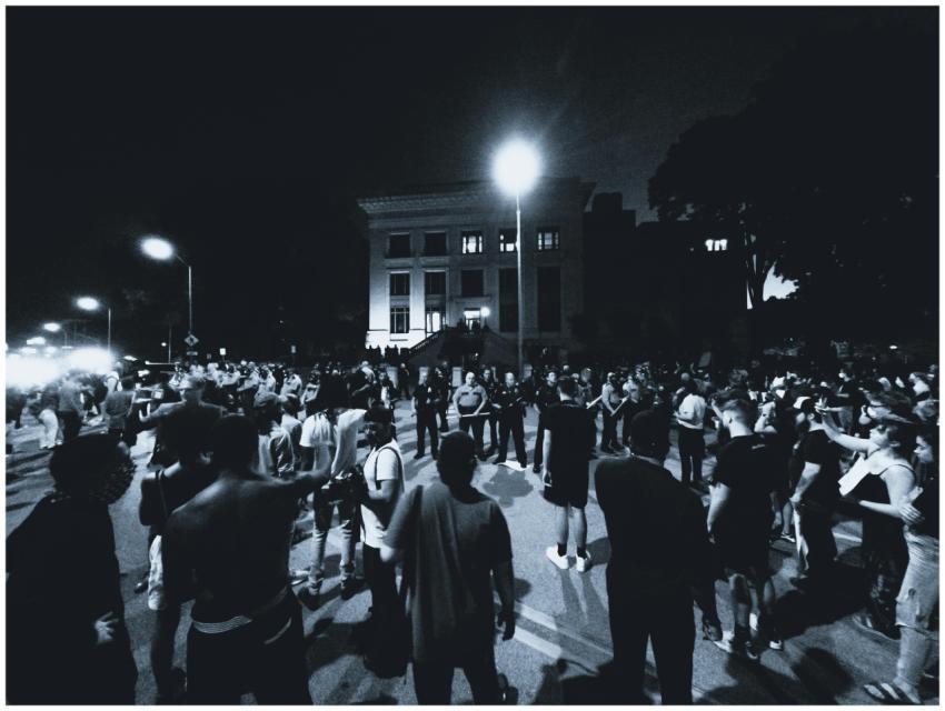 A monochrome scene of a large crowd gathering for