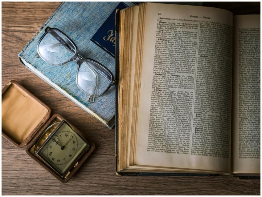 A vintage setting with antique books, watch, and r