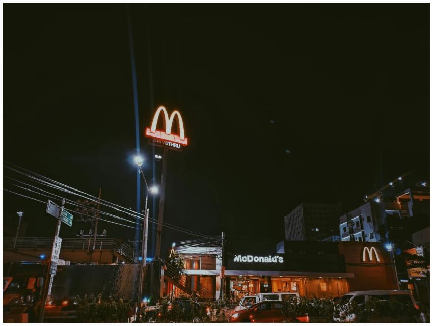 A brightly lit McDonald's restaurant in a city set