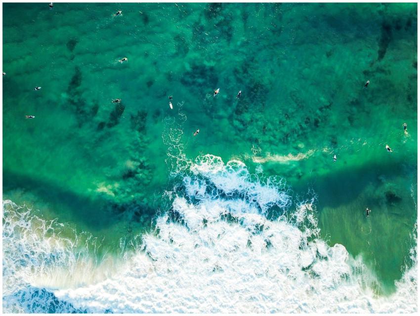 Stunning aerial shot of surfers riding waves in Po