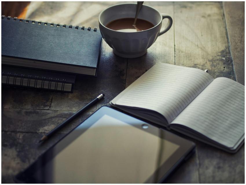 A cozy workspace setup with coffee, notebook, and