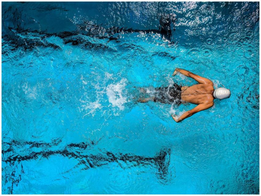 Top view of a swimmer wearing a cap, performing a