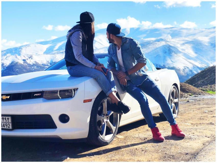 A young couple enjoys a scenic mountainous view wh