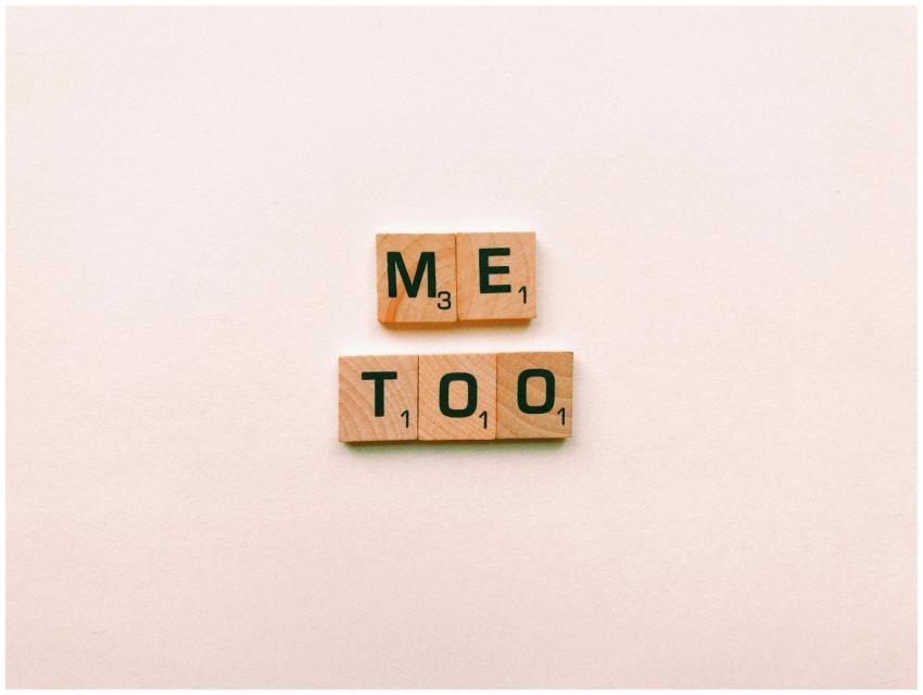 Wooden tiles spelling 'Me Too' on a plain backgrou