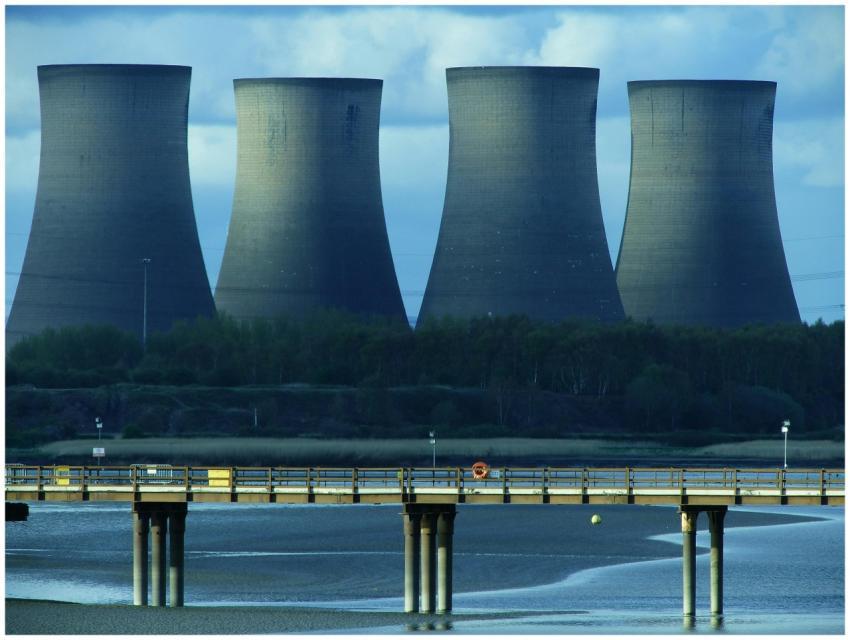 View of industrial cooling towers and a bridge ove