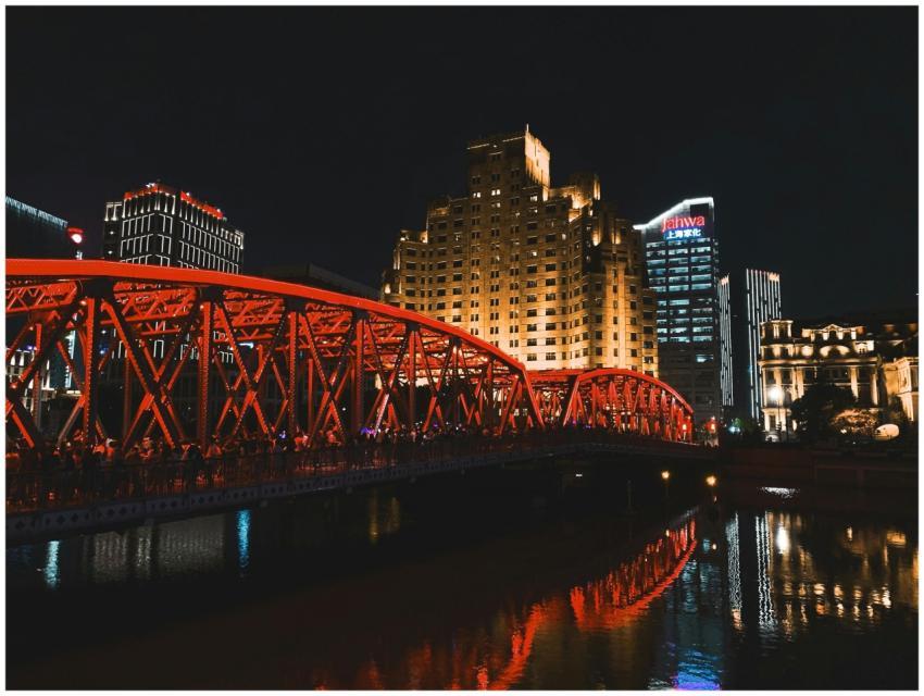Lively city skyline with a striking red bridge lit