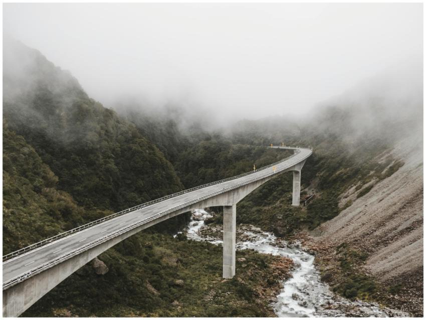 Scenic view of a bridge over a river in a foggy mo