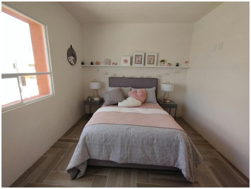 A cozy minimalist bedroom featuring soft pink acce