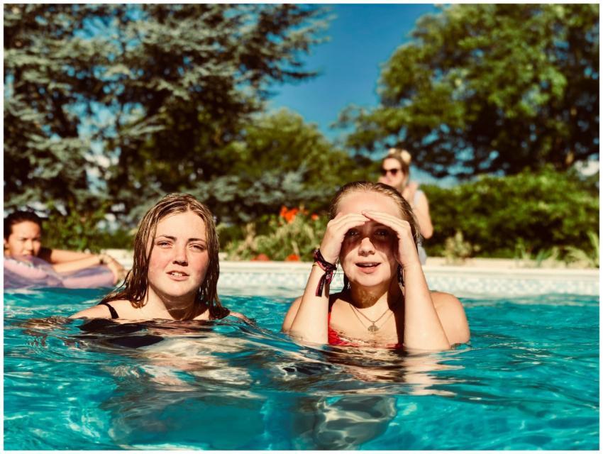 Two women enjoying a sunny day in a swimming pool,