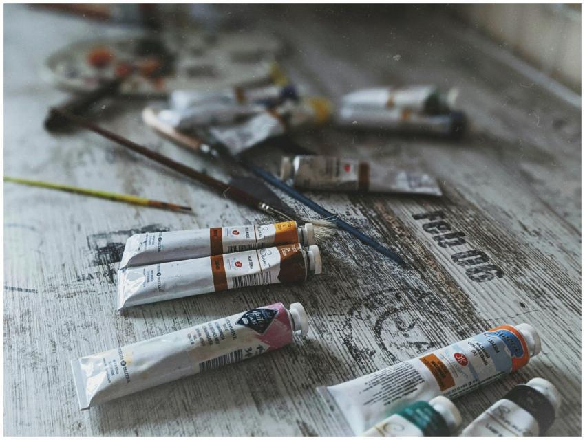 Close-up of various acrylic paint tubes and brushe