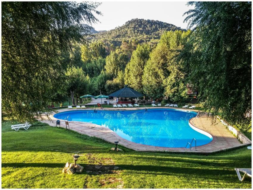 Relax at a luxury resort pool surrounded by lush g