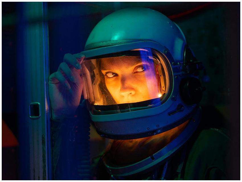 Portrait of a spacewoman in a helmet gazing intens