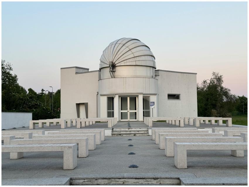 A modern observatory building under a clear twilig